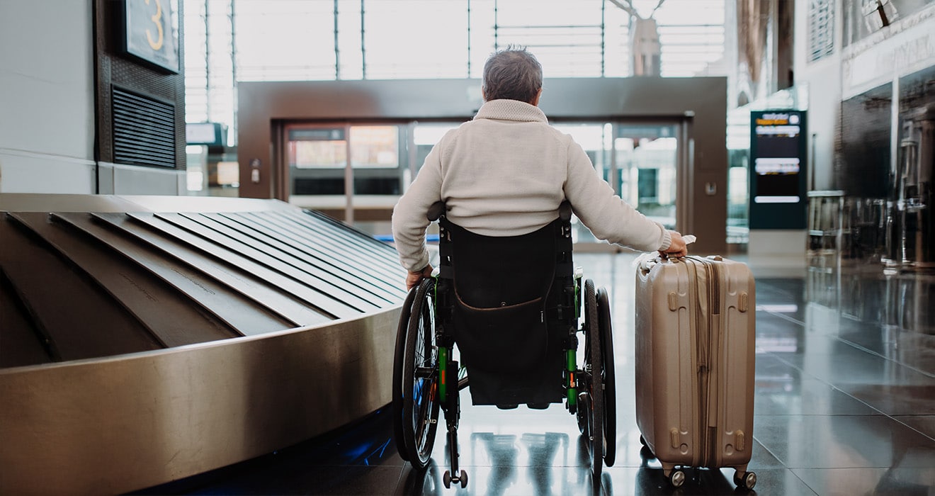 Person im Rollstuhl am Flughafen auf Reisen