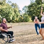 Familie im Ausland, mit Rollstuhl im Park, Federball spielend