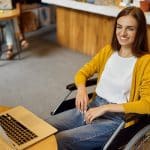 Junge Frau sitzt in gemietetem Rolstuhl