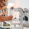 Person überprüft eine Online-Checkliste für das Rollstuhlmieten neben einem Rollstuhl