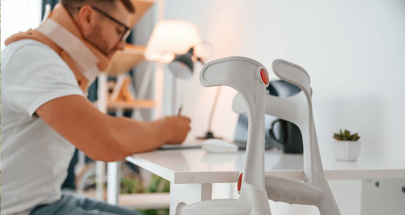 Person überprüft eine Online-Checkliste für das Rollstuhlmieten neben einem Rollstuhl