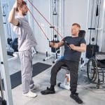 Person in der Reha-Phase sitzt in einem Rollstuhl in einem hellen Therapiebereich