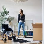 Person verpackt einen Rollstuhl für die Rücksendung in den Originalkarton