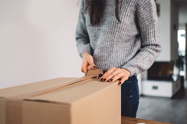 Checkliste Rollstuhl mieten: Diese Punkte sollten Sie vor der Buchung klären – Person verpackt einen Rollstuhl zur Rücksendung in den Originalkarton